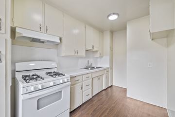 Wilmington apartment for rent - A white kitchen with a stove and cabinets.