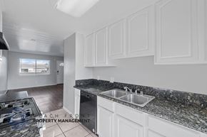 Long Beach apartment for rent - A kitchen with granite countertops and white cabinets.