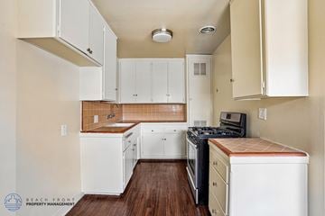 Gardena apartment for rent - A kitchen with white cabinets and a wooden countertop.