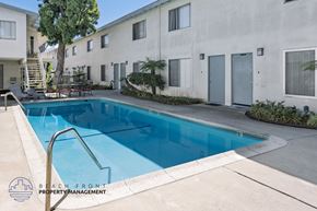 Torrance apartment for rent - A swimming pool in front of a building with the words "Beach Front Property Management" on the bottom left.