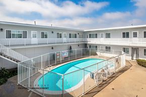 Hawthorne apartment for rent - A pool surrounded by a fence in a sunny courtyard.