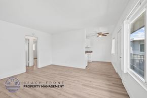 Long Beach apartment for rent - a living room with white walls and wood floors and a ceiling fan