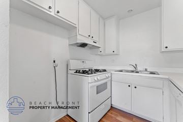 Huntington Beach apartment for rent - A white kitchen with a stove and sink.