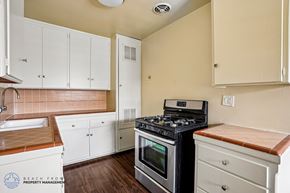 Gardena apartment for rent - A kitchen with a stove, sink, and cabinets.