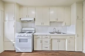Wilmington apartment for rent - A white kitchen with a stove, sink, and cabinets.