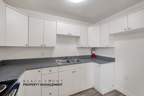 Long Beach apartment for rent - A kitchen with white cabinets and a grey countertop.