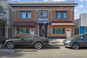 Long Beach apartment for rent - the front of the now leasing building with two cars parked in front