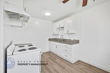 Long Beach apartment for rent - a kitchen with white cabinets and a stove and a sink