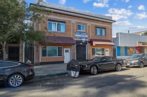 Long Beach apartment for rent - a parking lot with cars parked in front of a brick building