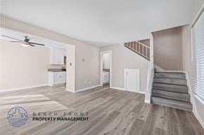 Redondo Beach apartment for rent - A spacious room with wooden flooring and a staircase leading to another level.