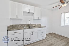 Long Beach apartment for rent - a kitchen with white cabinets and a granite counter top