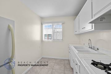 Long Beach apartment for rent - a kitchen with white cabinets and a sink and a window