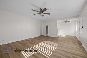 Downey apartment for rent - A spacious room with a ceiling fan and wooden flooring.
