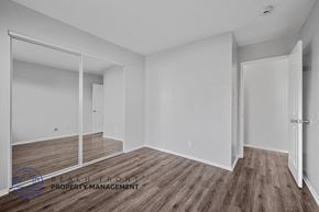 Long Beach apartment for rent - A room with wooden flooring and white walls, with a mirror on the left side.