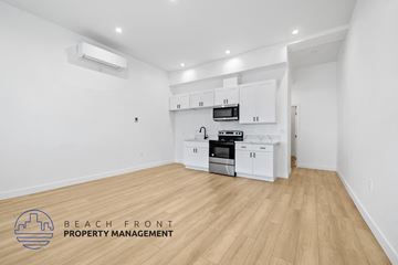 Long Beach apartment for rent - a white kitchen with white cabinets and white appliances and a wooden floor
