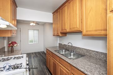 Downey apartment for rent - A kitchen with wooden cabinets and a stove top.