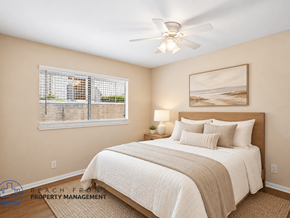 Lakewood apartment for rent - A bedroom with a large bed and a painting of a beach scene on the wall.