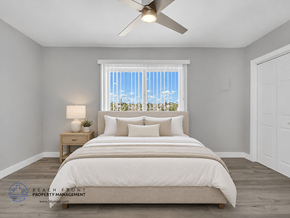 Redondo Beach apartment for rent - A bedroom with a large bed, a ceiling fan, and a window with a view of the beach.