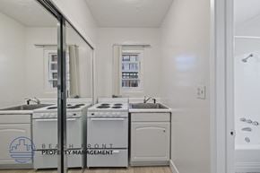 Inglewood apartment for rent - a white kitchen with white appliances and a window and a mirror