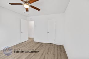 Long Beach apartment for rent - a bedroom with white walls and wood floors and a ceiling fan