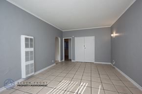 Long Beach apartment for rent - A spacious room with tiled flooring and white doors and windows.