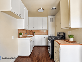 Gardena apartment for rent - A kitchen with white cabinets and a black stove top oven.