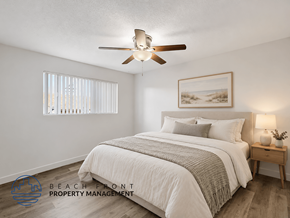 Long Beach apartment for rent - A bedroom with a bed, a ceiling fan, and a nightstand with a lamp.