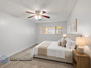Downey apartment for rent - A bedroom with a bed, nightstand, and a ceiling fan.