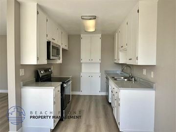 Redondo Beach apartment for rent - a kitchen with white cabinets and stainless steel appliances