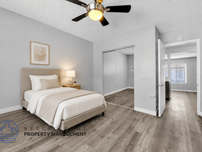Long Beach apartment for rent - A bedroom with a bed, a ceiling fan, and a wooden floor.