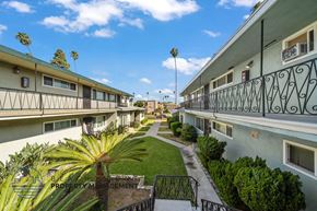Inglewood apartment for rent - a row of apartments with balconies and a courtyard with palm trees