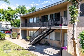 Anaheim apartment for rent - A two-story house with a balcony and a staircase leading to the second floor.