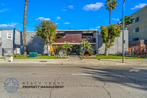 Santa Ana apartment for rent - A street view with a building and palm trees in front of it.