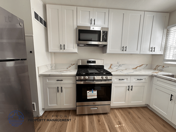Santa Ana apartment for rent - A kitchen with white cabinets and a stainless steel refrigerator.