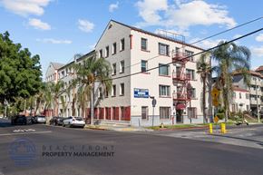 Los Angeles apartment for rent - a large white building at the corner of a street with palm trees