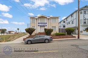 Redondo Beach apartment for rent - A car is parked in front of a building with the sign "NOW LEASING" on it.