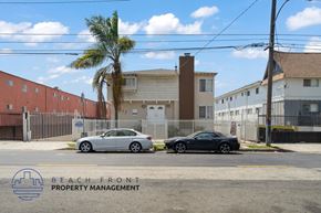 Inglewood apartment for rent - Two cars parked in front of a building with a palm tree and a sign that says