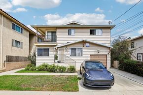 San Pedro apartment for rent - A grey car is parked in front of a two-story house.