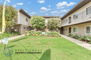 Lomita apartment for rent - a green lawn in front of a building with trees and plants