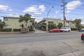 Huntington Park apartment for rent - A street view with cars and buildings.