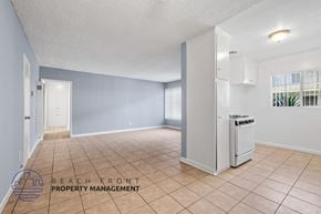 Gardena apartment for rent - A spacious room with a refrigerator and a window with blinds.