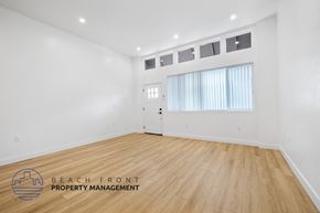 Long Beach apartment for rent - a living room with white walls and wood flooring and a white door