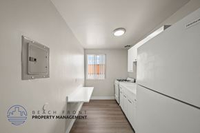 Hawthorne apartment for rent - A clean, white kitchen with a washer and dryer built in.