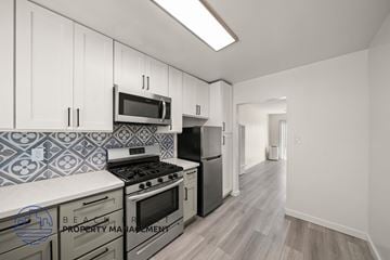 Los Angeles apartment for rent - A kitchen with a stove top oven and a microwave above it.