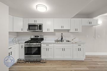 Anaheim apartment for rent - A kitchen with white cabinets and a stove top oven.