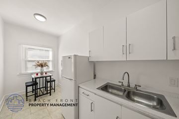 Los Angeles apartment for rent - A kitchen with a sink, refrigerator, and a window with a table and chairs.