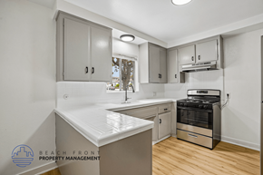 San Pedro apartment for rent - A kitchen with a stove, sink, and cabinets.