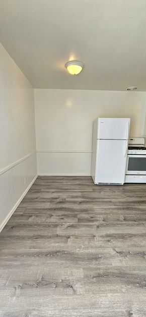 Redondo Beach apartment for rent - A white fridge in a room with wooden flooring.