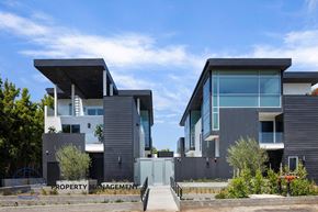 West Hollywood apartment for rent - a row of modern houses with black facade and a blue sky