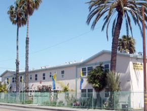 Lennox apartment for rent - a large white building with palm trees in front of it